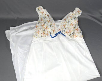 May include: A white sleeveless nightgown with a floral print on the bodice and a blue ribbon bow. The gown has a V-neckline and a flowing skirt.