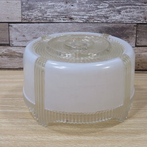 May include: A white frosted glass ceiling light fixture with a clear glass top and a ribbed design around the bottom edge.