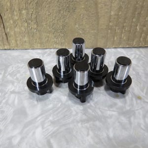 May include: A collection of seven black and chrome cabinet knobs. Each knob features a cylindrical chrome body with a flat, black top and a circular black base. The knobs are arranged on a light-colored surface.