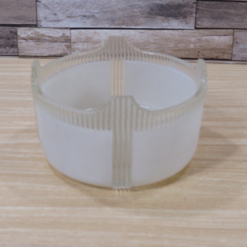 May include: White frosted glass bowl with a decorative ribbed design. The bowl has a round shape and a wide opening.