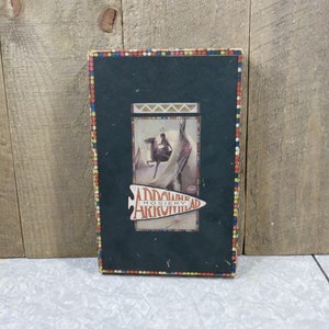 May include: Vintage Arrowhead Hosiery box with a colorful border. The box features a black and white illustration of a Native American riding a horse with a feathered headdress.