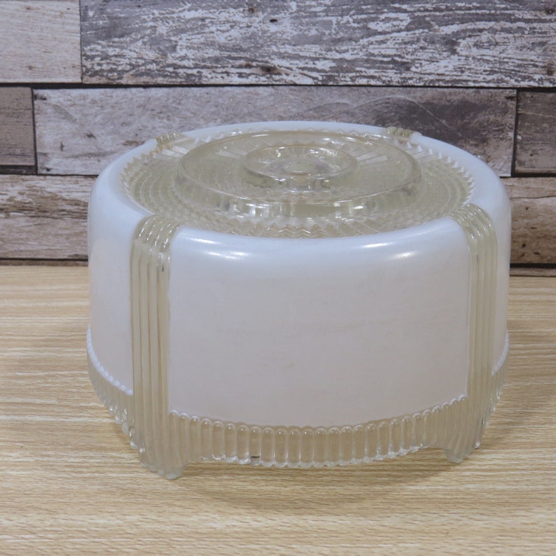 May include: A white frosted glass ceiling light fixture with a clear glass top and a ribbed design around the bottom edge.