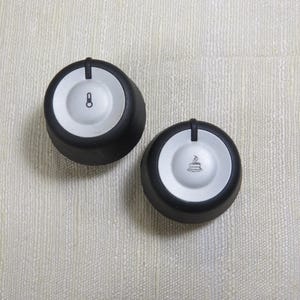 May include: Two black and silver appliance knobs. One knob has a power symbol and the number 8. The other knob has a coffee cup symbol. Both knobs have a raised indicator line.
