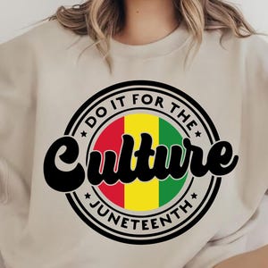 May include: A beige sweatshirt with a black circle graphic that says "Do It For The Culture Juneteenth" with a red, yellow, and green flag inside the circle.