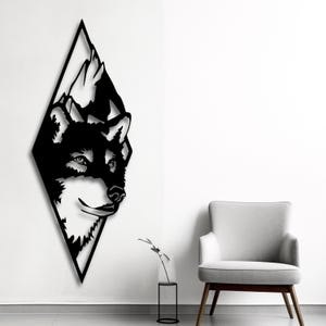 Könnte beinhalten: Schwarze Wandkunst aus Metall mit einem Wolfskopf in einer Diamantform.