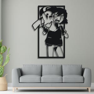Op de afbeelding: Zwarte en witte silhouet wandkunst met een cartoonfiguur dat een klein wezen vasthoudt. Het personage glimlacht en heeft een vastberaden uitdrukking. De kunst is ingelijst in een zwart vierkant.