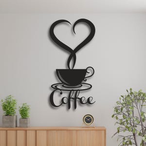Può includere: Arte da parete in metallo nero con una tazza di caffè con vapore a forma di cuore e la parola "Coffee" sotto.