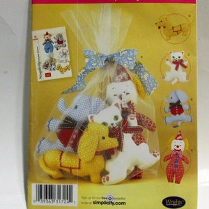May include: A set of five stuffed animal patterns for sewing. The patterns include a clown, a cat, a dog, an elephant, and a bear. The patterns are packaged in a clear plastic bag with a white ribbon.