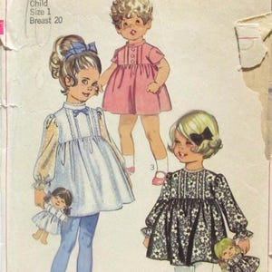 May include: Vintage Simplicity sewing pattern for a child's dress, size 1, with a breast measurement of 20 inches. The illustration shows three little girls in different dresses, including a pink dress, a blue dress, and a black and white floral dress.