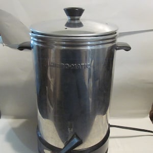 May include: A silver and black electric coffee percolator with a black handle and a red light. The percolator has the word "MIRO-MATIC" printed on the side.