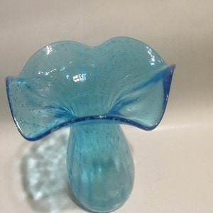 May include: A light blue glass vase with a ruffled top and a textured, bubbly surface.