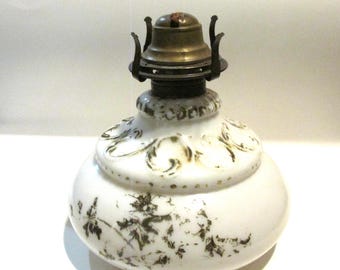 May include: White milk glass oil lamp with a gold floral design and a brass burner.