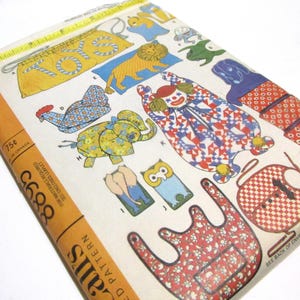 May include: A vintage sewing pattern for children's clothing. The pattern includes designs for a clown, elephant, lion, owl, and other whimsical characters. The pattern is printed on white paper with a yellow border and includes instructions for sewing the garments.