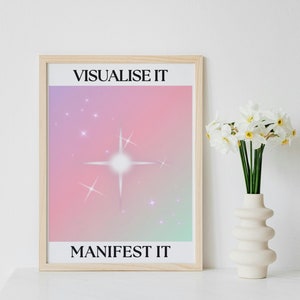 May include: A framed print with a pink and purple gradient background and a white star in the centre. The text "VISUALISE IT" is at the top and "MANIFEST IT" is at the bottom.