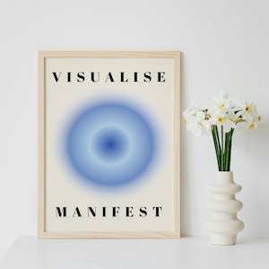 May include: A framed print with a light blue circle in the center and the text "VISUALISE MANIFEST" in black lettering.