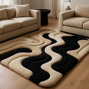 May include: A rectangular area rug featuring a high-pile, three-dimensional wavy pattern in alternating bands of black and beige. The surface texture appears soft and plush, with the text RUGS COLLECTION printed clearly on the upper left section.