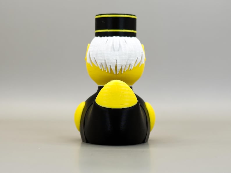 May include: A yellow figurine of a bellhop, viewed from the back. The figure has white hair, a black and yellow hat, and a black uniform with yellow accents. The design is a 3D print.
