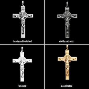 May include: Four crucifix pendants in various finishes: Oxide and Polished, Oxide and Matt, Polished, and Gold Plated. Each pendant shows a detailed depiction of Jesus on the cross, with the INRI inscription above. The pendants are displayed against a black background.