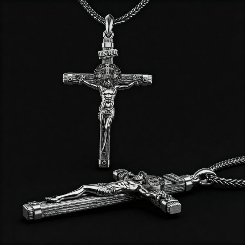 Puede incluir: Collar con colgante de cruz crucifijo plateado. La cruz presenta una representaci&oacute;n detallada de Jesucristo, con las letras INRI arriba. El colgante est&aacute; suspendido de una cadena plateada. La imagen muestra dos crucifijos, uno de pie y otro tumbado.