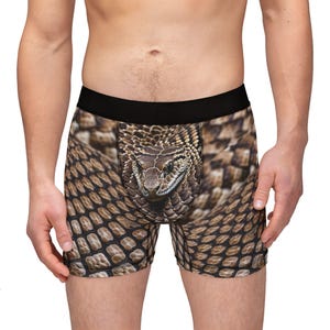 Könnte beinhalten: Braune und schwarze Boxershorts mit Schlangenmuster. Der Kopf der Schlange ist auf der Vorderseite der Shorts sichtbar.