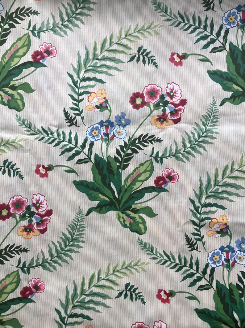 May include: A patterned fabric with a cream background and vertical stripes. The design showcases green fern leaves and clusters of red, yellow, and blue flowers. The repeating pattern creates a botanical theme, suitable for various textile applications.