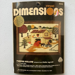 May include: A vintage "Dimensions" crewel embroidery kit featuring a framed scene of "Pumpkin Hollow." The kit includes Persian wool yarn, cotton embroidery floss, and a printed design on cotton cloth. The frame size is 7 x 5 inches.