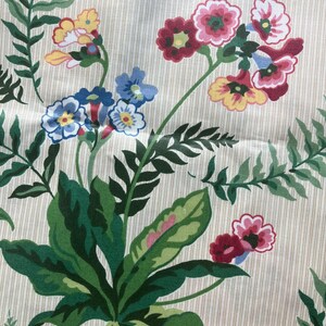 May include: Fabric with a cream background and vertical stripes. The pattern features green leaves and colourful flowers in shades of red, pink, yellow, and blue. The design has a botanical theme, suitable for various textile projects.