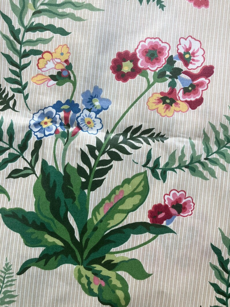 May include: Fabric with a cream background and vertical stripes. The pattern features green leaves and colourful flowers in shades of red, pink, yellow, and blue. The design has a botanical theme, suitable for various textile projects.
