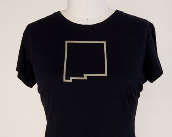 May include: Black t-shirt with a gold outline of the state of New Mexico.