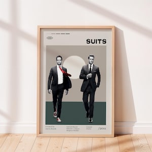 Può includere: Un poster incorniciato con il titolo "SUITS" in alto, con due uomini in abito. Il poster include i nomi degli attori e l'anno 2011. Lo sfondo è grigio chiaro con una striscia verde scuro.