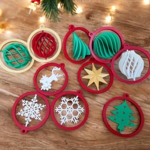 May include: Nine red and white Christmas ornaments with various designs, including a snowflake, a deer, a star, a tree, and a spiral. The ornaments are made of a 3D printed material.