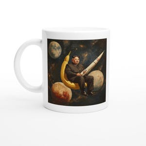 以下が含まれることがあります： 宇宙でバナナに座っている男性のカラフルな画像が描かれた白いセラミックマグカップ。男性はロケットを持っており、背景には惑星があります。