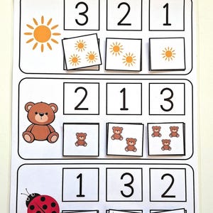 Könnte beinhalten: Ein weißes Lernblatt mit drei Reihen von Zählübungen. Jede Reihe zeigt eine Sonne, einen braunen Teddybären oder einen roten Marienkäfer, gefolgt von Kästchen mit den Zahlen 1, 2 und 3 sowie den entsprechenden Symbolgruppen.