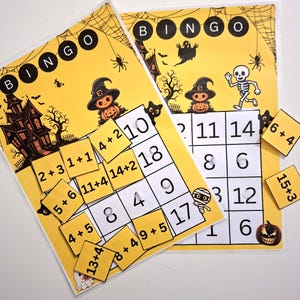 Könnte beinhalten: Halloween-Bingo-Spiel mit gelbem Hintergrund. Das Spiel zeigt ein Spukhaus, Kürbisse und ein Skelett. Die Bingo-Karten haben Zahlen und Rechenaufgaben. Enthält lose Zahlkarten zum Spielen.