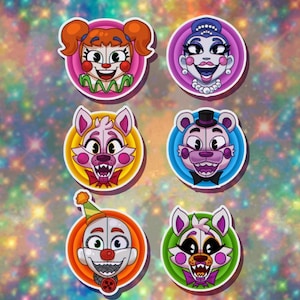 May include: Six colourful round stickers featuring cartoon characters from the popular video game franchise Five Nights at Freddy's. The characters include Circus Baby, Funtime Foxy, Funtime Freddy, Ballora, Ennard, and  Minireena.