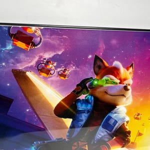 May include: Framed artwork featuring a cartoon fox in a futuristic setting. The fox, with orange fur and green goggles, is set against a vibrant purple and orange space background. The artwork includes flying vehicles and a spaceship.