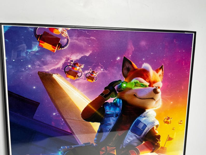 May include: Framed artwork featuring a cartoon fox in a futuristic setting. The fox, with orange fur and green goggles, is set against a vibrant purple and orange space background. The artwork includes flying vehicles and a spaceship.