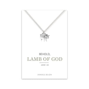 May include: Silver necklace with a small silver lamb charm. The necklace has a card attached to it that says "Behold, Lamb of God" and "John 1:29" with the brand name "Doodle Beads".