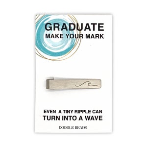 May include: Silver tie bar with a wave design. The card reads "Graduate Make Your Mark" and "Even a tiny ripple can turn into a wave." The card is white with a blue and gold circle design. The brand name "Doodle Beads" is printed at the bottom of the card.
