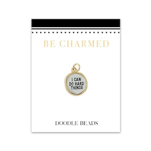 May include: Gold charm with the text "I can do hard things" on a white background. The charm is on a white card with the text "Be Charmed" and "Doodle Beads".