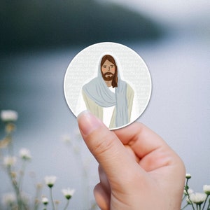 Könnte beinhalten: Ein weißer runder Aufkleber mit einer hellblauen und beigen Illustration von Jesus. Der Aufkleber hat den Text "Ich glaube an Christus" wiederholt am Rand.