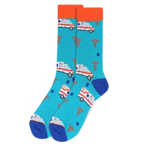 May include: A pair of blue socks with a white ambulance and red medical symbol pattern. The socks have orange cuffs.