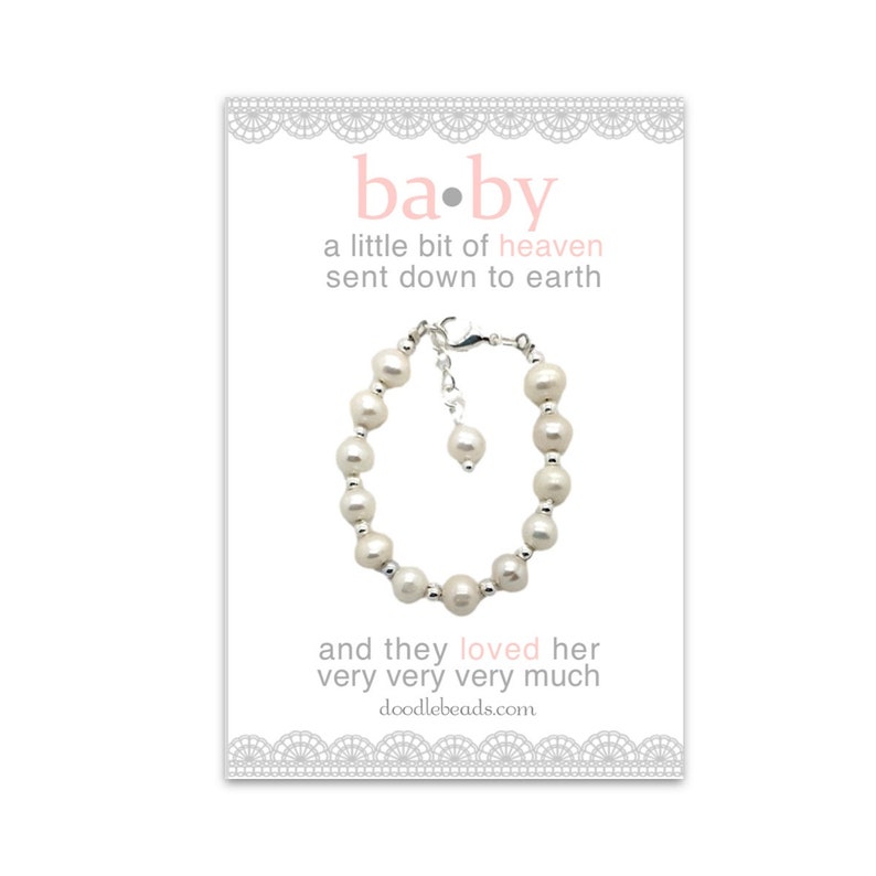 May include: A white pearl bracelet with a silver clasp and a small charm. The card reads "ba.by a little bit of heaven sent down to earth and they loved her very very very much doodlebeads.com"