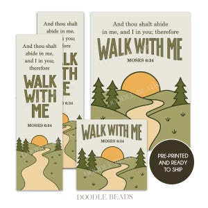 Pode incluir: Um conjunto de cartões e marcadores pré-impressos com o texto "Walk With Me" e uma ilustração paisagística de um caminho, sol e árvores. Os cartões e marcadores são de vários tamanhos e formas.