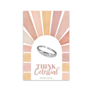 May include: A silver ring with a sun design on a pink and orange watercolor background. The text "THINK Celestial" and "DOODLE BEADS" is below the ring.