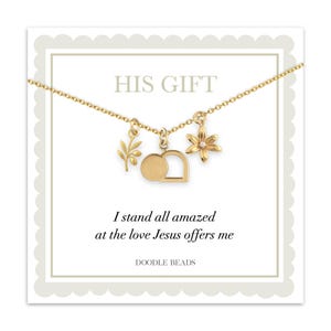 Könnte beinhalten: Eine goldfarbene Halskette mit drei Anhängern: einem Olivenzweig, einem Grab und einer Blume mit einem kleinen Edelstein. Die Halskette wird auf einer weißen Karte mit dem Text "HIS GIFT" und einem religiösen Zitat präsentiert. Der Markenname "DOODLE BEADS" ist ebenfalls sichtbar.