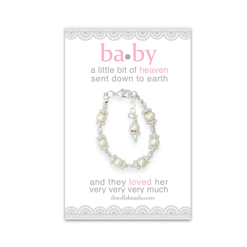 May include: A white pearl bracelet with a silver clasp and a small pearl charm. The bracelet is on a white card with the text "ba.by a little bit of heaven sent down to earth and they loved her very very very much doodlebeads.com"