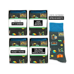 Può includere: Quattro paia di calzini in scatole con diversi giochi di parole a tema finanziario. I calzini sono grigi con polsini blu e presentano una varietà di icone finanziarie, tra cui grafici, denaro e una valigetta. I calzini sono confezionati in scatole bianche con un'etichetta bianca che include un gioco di parole sul tema finanziario. Il testo sulle etichette recita: "Fidati di me, sono un banchiere", "Continuo a sentire fatture", "Faccio muovere i soldi" e "Pianificatore finanziario totalmente fantastico". Il quinto calzino è mostrato fuori dalla scatola ed è dello stesso design dei calzini nelle scatole. Il testo sul calzino recita: "Eccello nella creazione di fogli di calcolo".