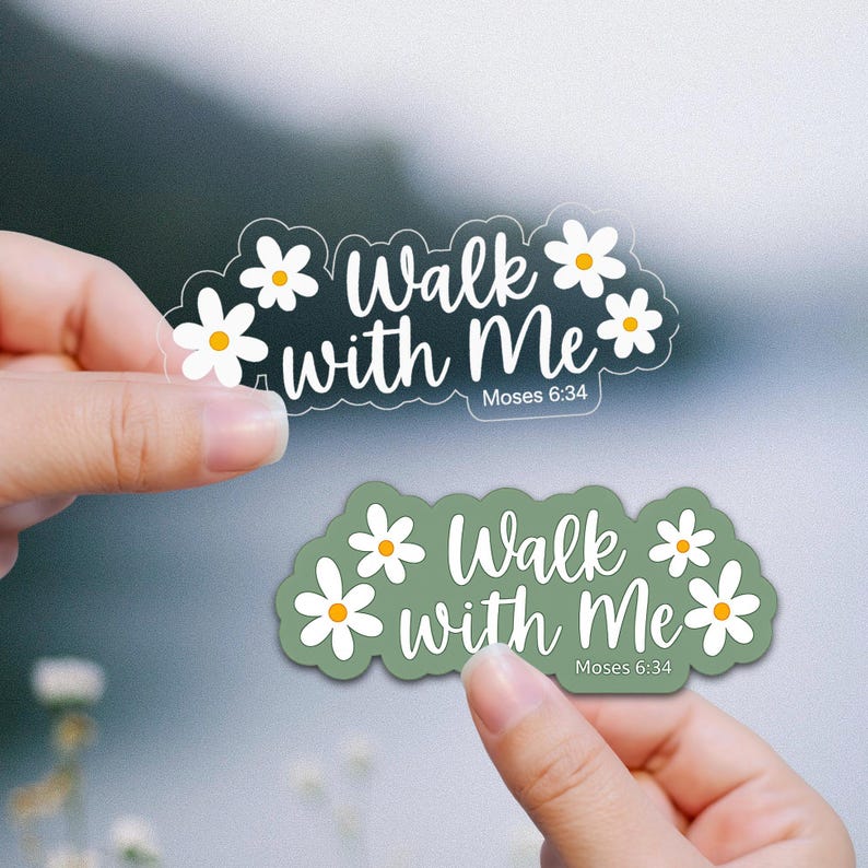 May include: Two stickers with the phrase "Walk with Me" and the reference "Moses 6:34". One sticker is clear with white text and daisy accents. The other is olive green with white text and daisy accents.