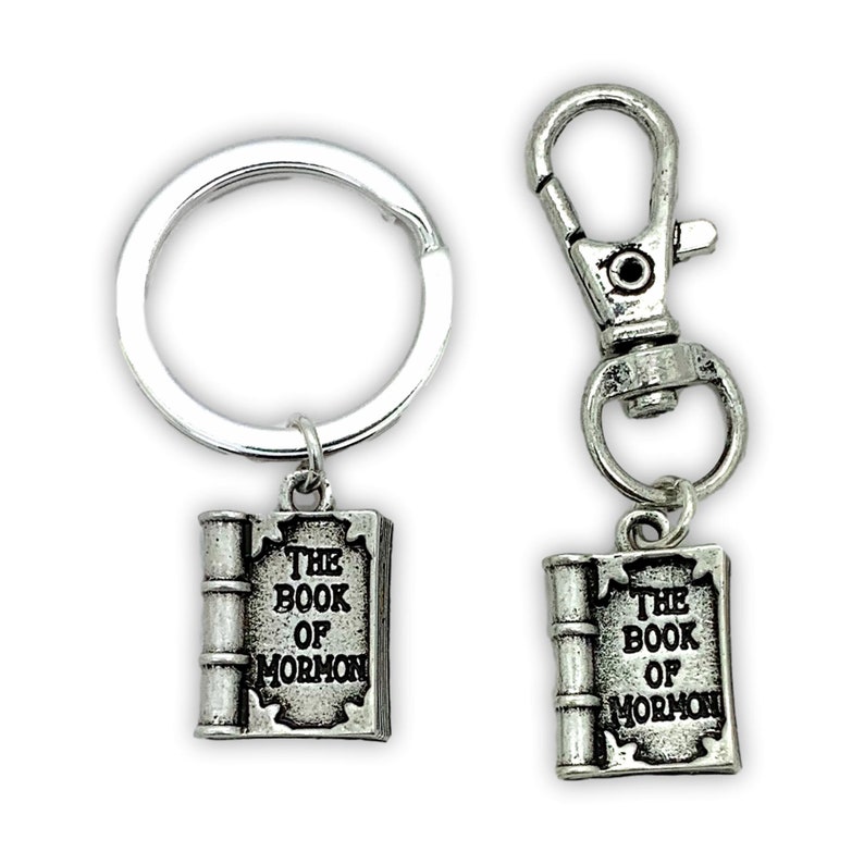 May include: Two silver keychains with a book charm. The charms feature the text "The Book of Mormon".